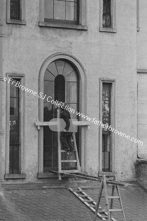 MAN FITTING LEADED GLASS TO RERE OF 35 LEESON STREET